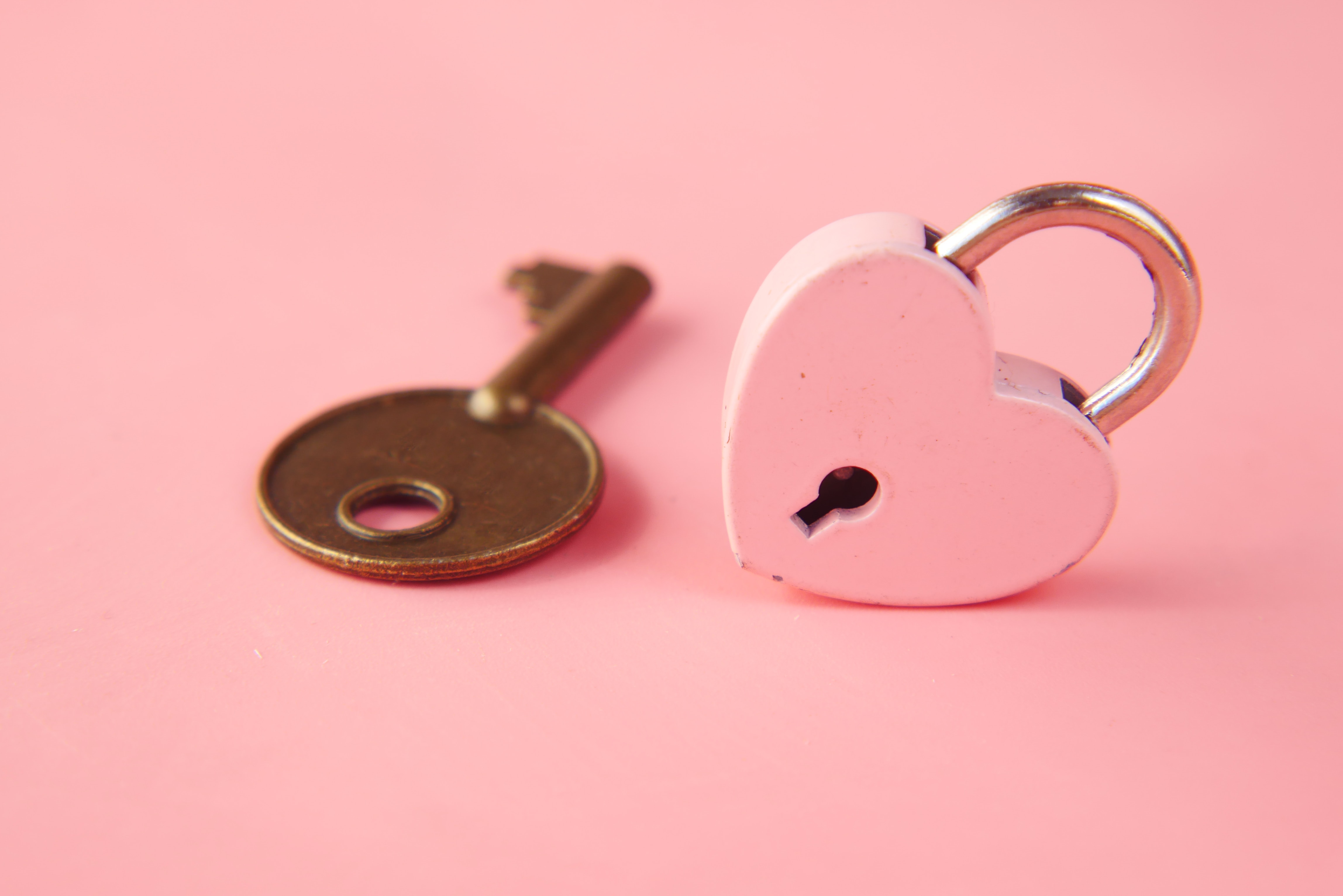 pink heart shaped lock withkey besides it