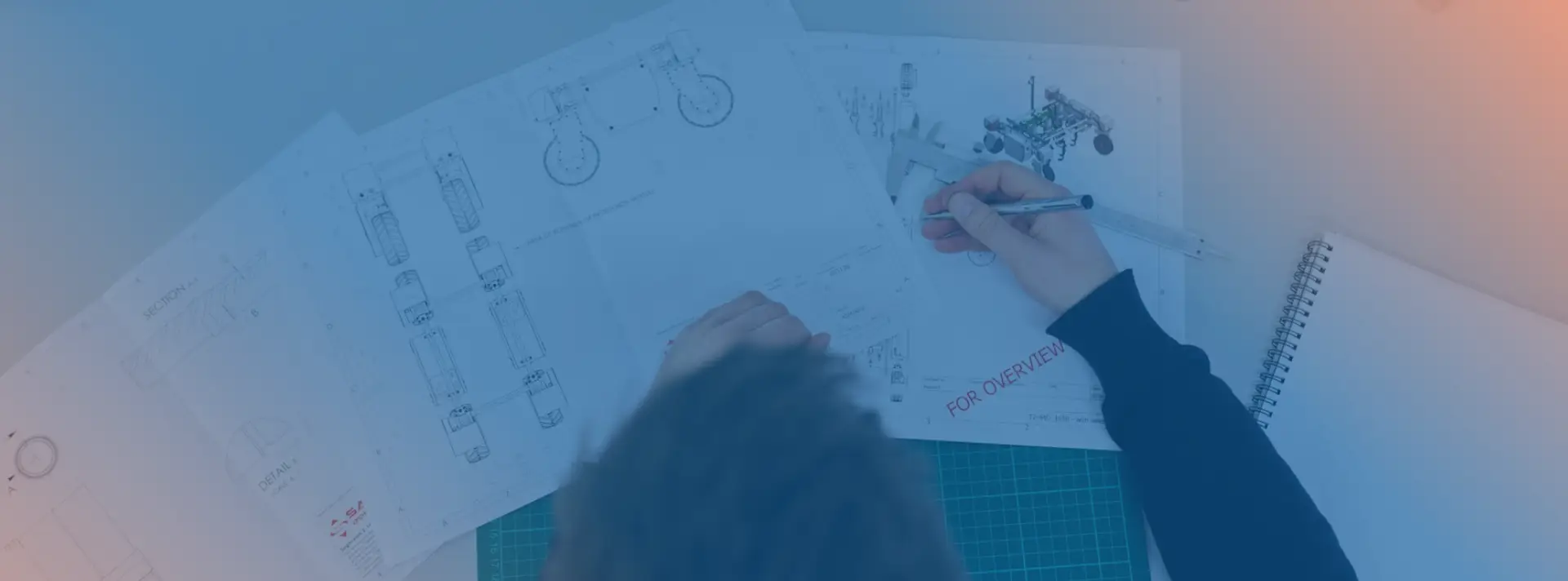 A woman who works in engineering, drawinga and sketching out a blueprint